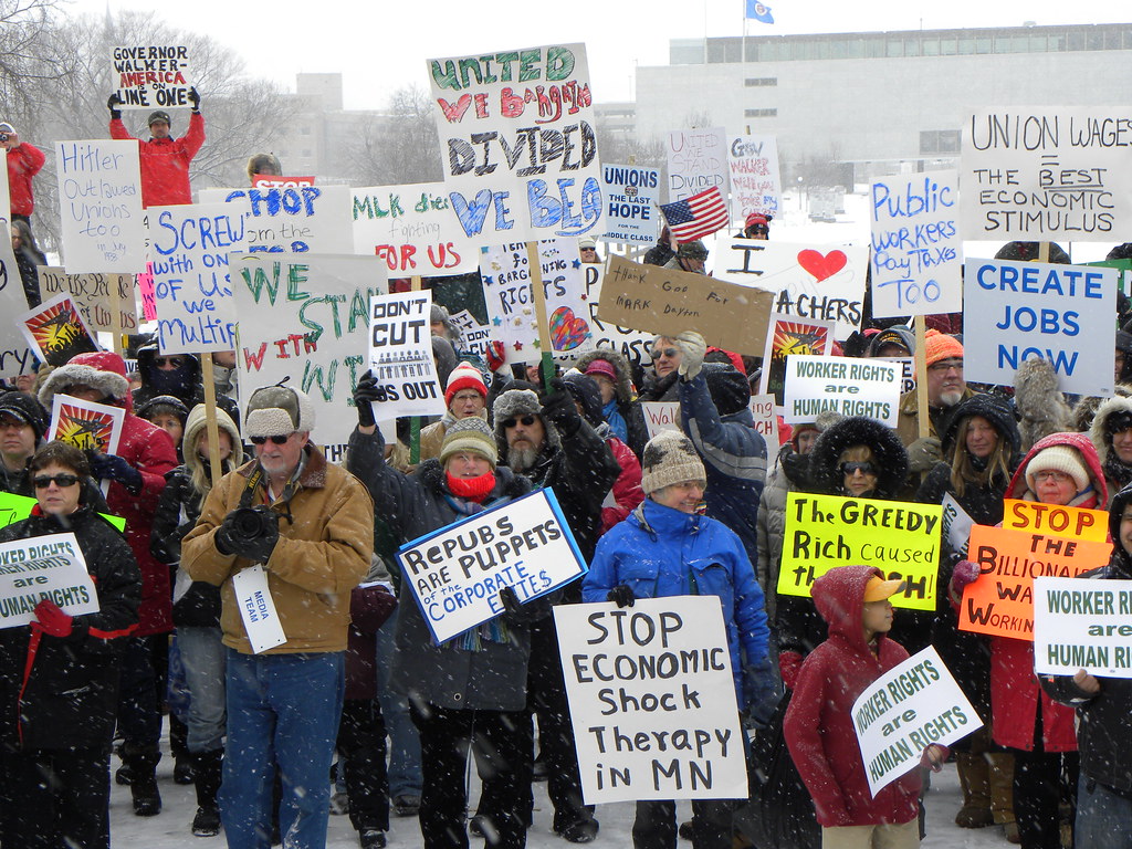 A crowd of protesters gathered at a rally holding signs in support of union workers.